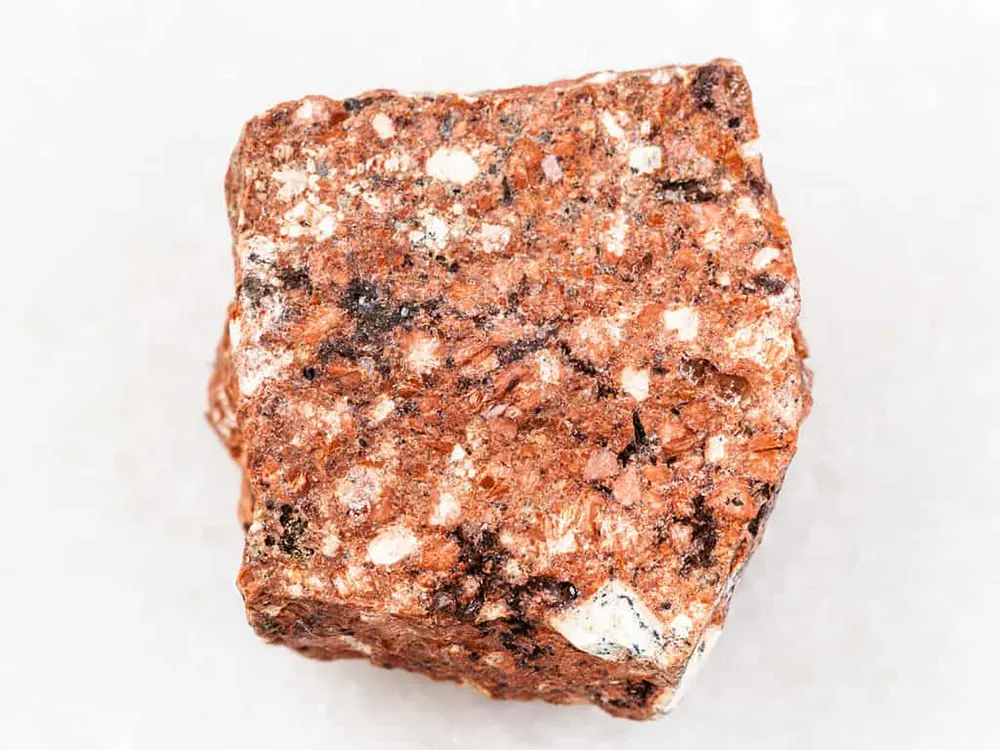 سنگ داسیت (Dacite) سنگ داسیت (Dacite) یک سنگ آذرین آتشفشانی است که از گدازه‌های ماگمایی با درصد سیلیکای متوسط تشکیل شده است. این سنگ از نظر ترکیبی بین آندزیت و ریولیت قرار دارد. داسیت‌ها عمدتاً از کانی‌های فلدسپات پلاژیوکلاز، بیوتیت، و پیروکسن تشکیل شده‌اند. این سنگ‌ها می‌توانند حاوی مقادیر کمی از کانی‌های دیگر مانند کوارتز، کلسیت، و هورنبلند نیز باشند. داسیت‌ها معمولاً دارای رنگ خاکستری مایل به قرمز یا قهوه‌ای هستند. این سنگ‌ها دارای بافت دانه‌ای متوسط تا درشت هستند. داسیت‌ها در مناطق آتشفشانی سراسر جهان یافت می‌شوند. این سنگ‌ها معمولاً در مناطق کوهستانی و در نزدیکی مناطق فرورانش یافت می‌شوند. داسیت‌ها کاربردهای مختلفی دارند. این سنگ‌ها در ساخت و ساز، جاده‌سازی، و صنایع مختلف مورد استفاده قرار می‌گیرند. در اینجا برخی از کاربردهای سنگ داسیت آورده شده است: ساخت و ساز: داسیت‌ها در ساخت و ساز به عنوان سنگ ساختمانی، سنگ نما، و سنگ فرش استفاده می‌شوند. جاده‌سازی: داسیت‌ها در جاده‌سازی به عنوان سنگ زیرسازی، سنگ آسفالت، و سنگ جدول استفاده می‌شوند. صنایع مختلف: داسیت‌ها در صنایع مختلف مانند صنعت ساختمان، صنعت سنگ، و صنعت معدن مورد استفاده قرار می‌گیرند. سنگ داسیت (Dacite) چیست